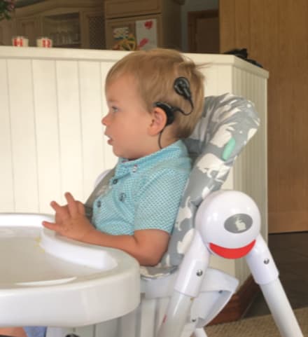 Image shows Henry sat in a high chair as a baby